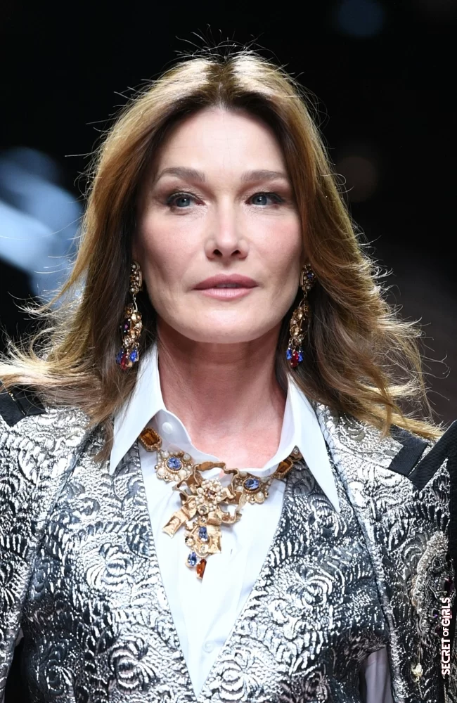 Carla Bruni and her shoulder-length hair with parting in the middle, walk for Dolce & Gabbana in Milan in September 2018 | Carla Bruni: Her Beauty Evolution In 50 Looks