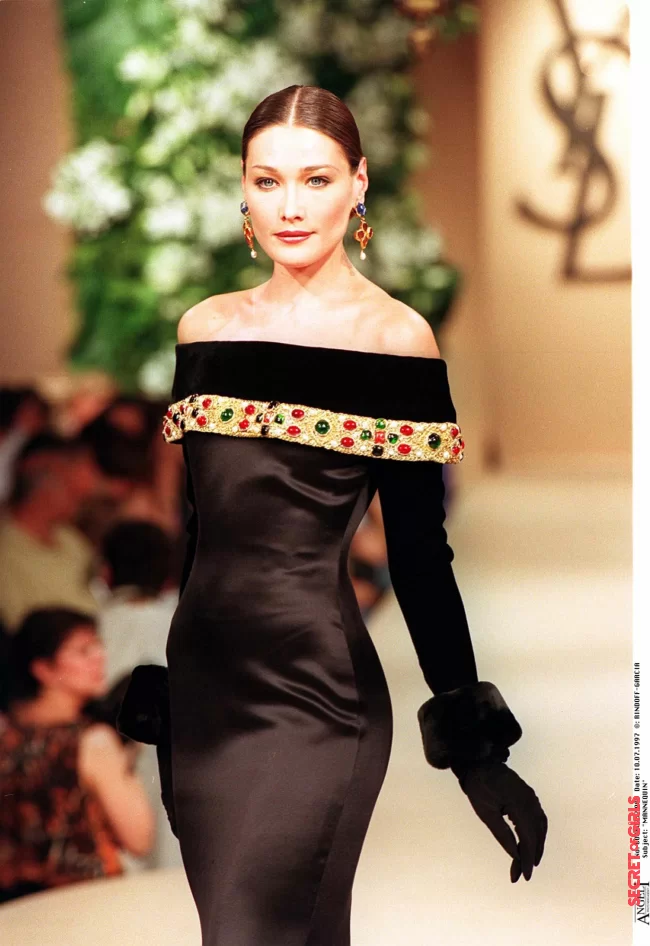 Carla Bruni and her ultra smooth bun with parting in the middle, on the Saint Laurent fashion show in 1997 in Paris | Carla Bruni: Her Beauty Evolution In 50 Looks