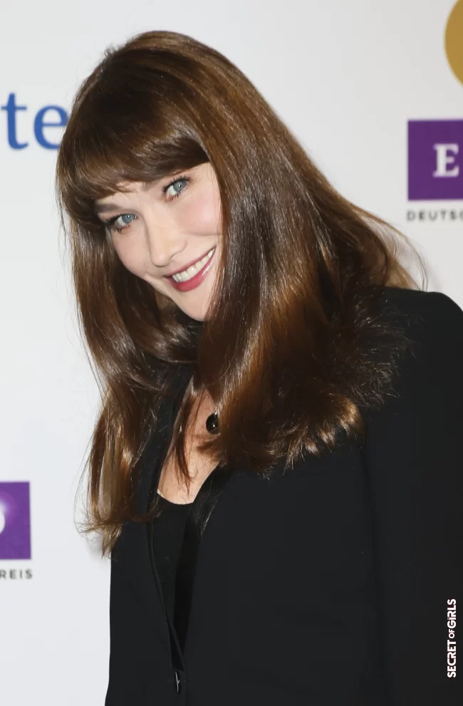 Carla Bruni and her long brown hair and thick bangs, in 2013 in Berlin | Carla Bruni: Her Beauty Evolution In 50 Looks