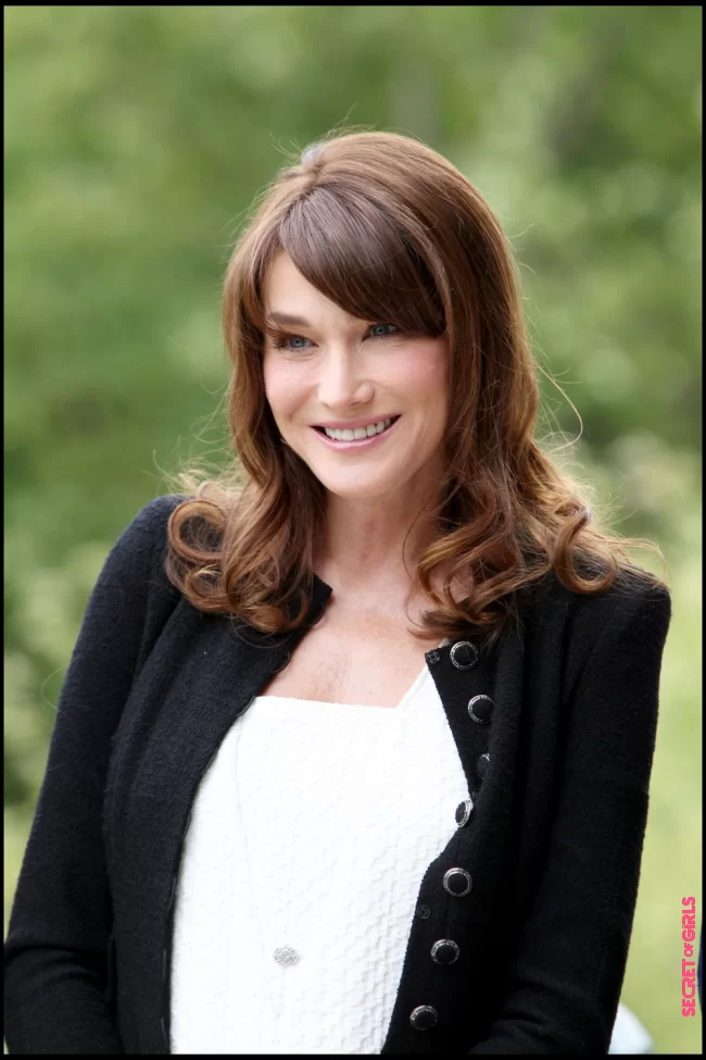 Carla Bruni and her curly brushing, with her long bangs on the side in Deauville in 2011 | Carla Bruni: Her Beauty Evolution In 50 Looks